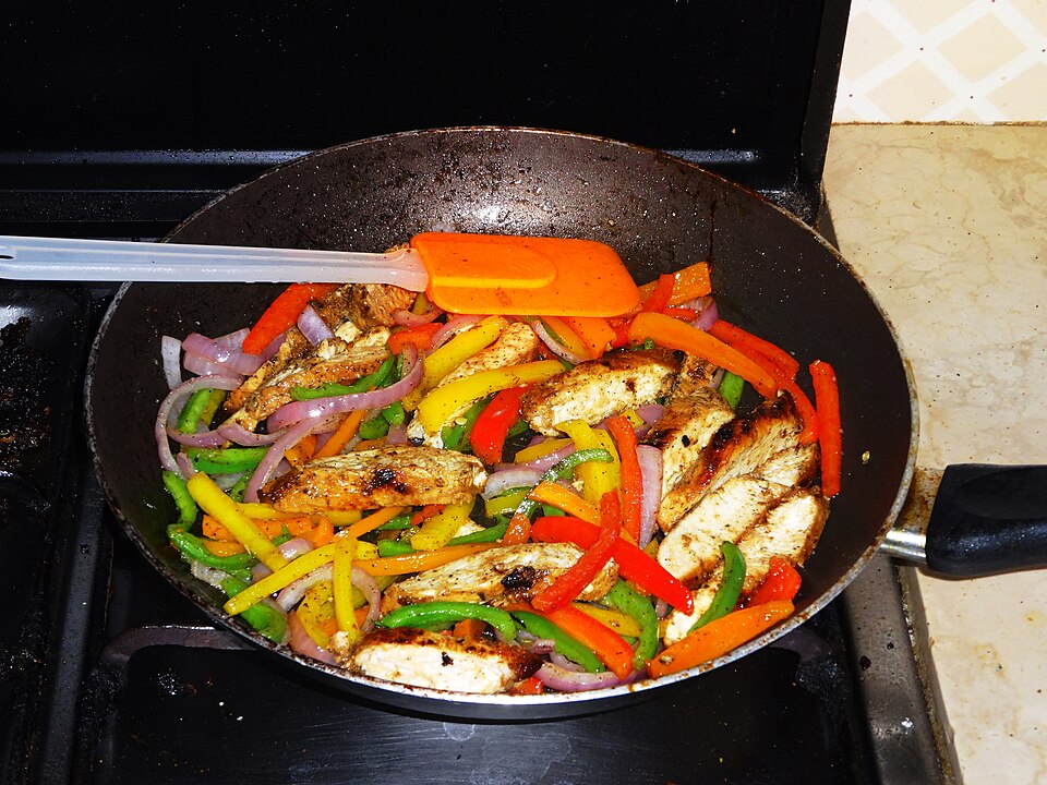 Chicken fajitas cooked with sliced bell peppers and onions